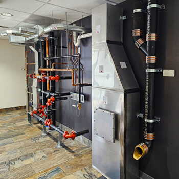 Trautman & Shreve lobby wall showcasing custom piping and HVAC offerings