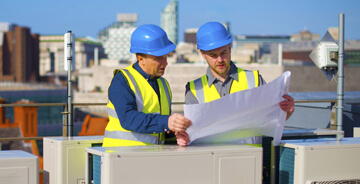 Two project managers discussing design-build plans at a job site